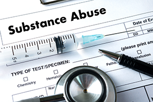 A medical substance abuse screening form sits beneath a stethoscope and syringe, suggesting clinical testing and a serious, cautionary tone.